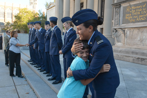 Cadet Carissa Silva of the University of New Haven hugs her little brother at the ROTC Oath of Enlistment ceremony.