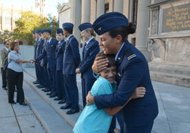 Cadet Carissa Silva of the University of New Haven hugs her little brother at the ROTC Oath of Enlistment ceremony.